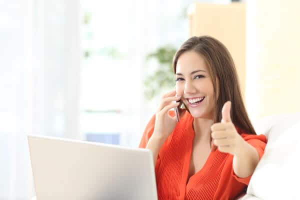Woman on laptop showing thumbs up